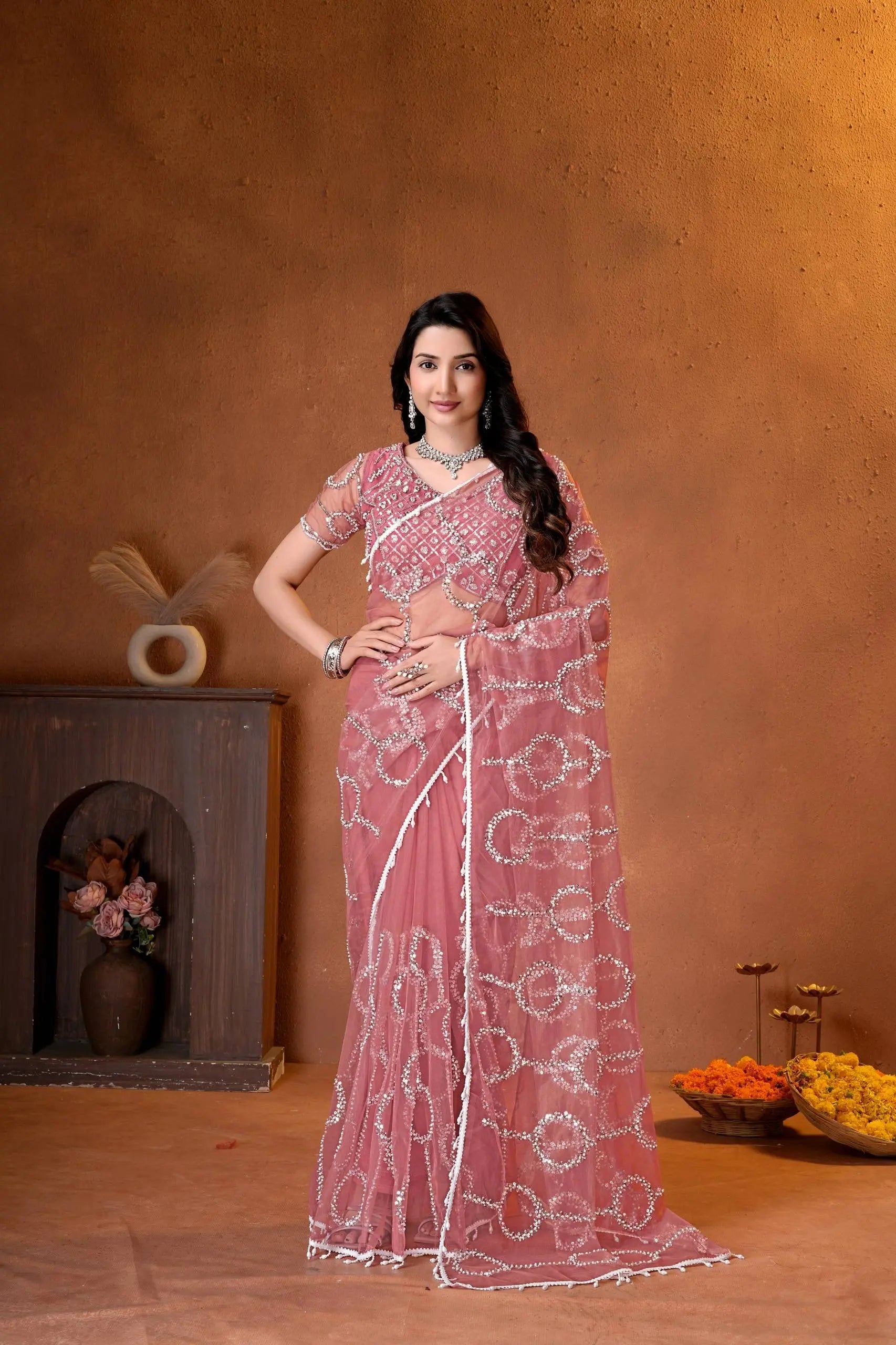 Elegant dusty pink saree adorned with shimmering sequins embroidery and intricate handcrafted detailing for a luxurious festive look.