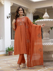 Woman wearing an orange embroidered outfit in a decorative setting