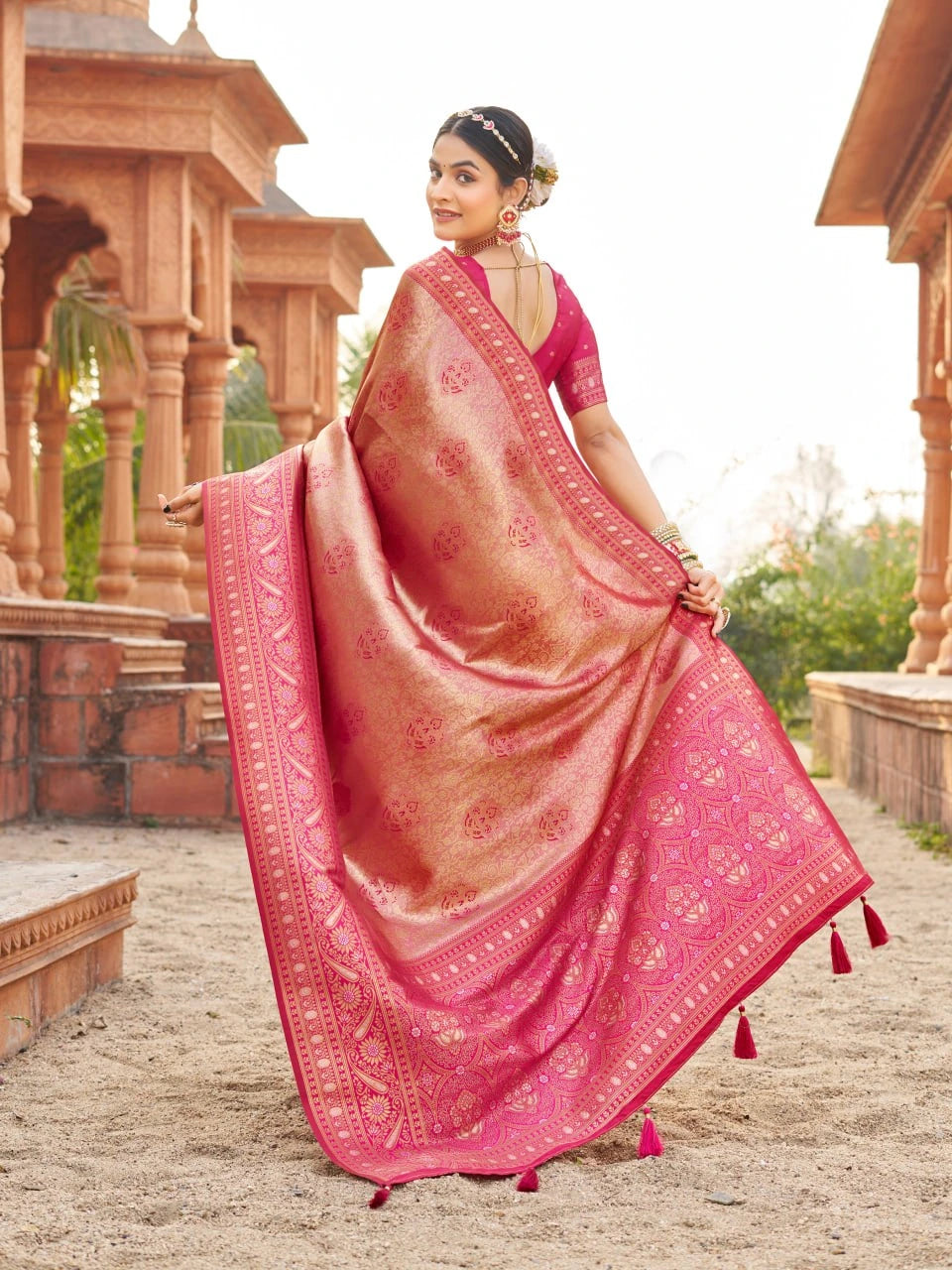 Woman in a pink saree with a traditional setting