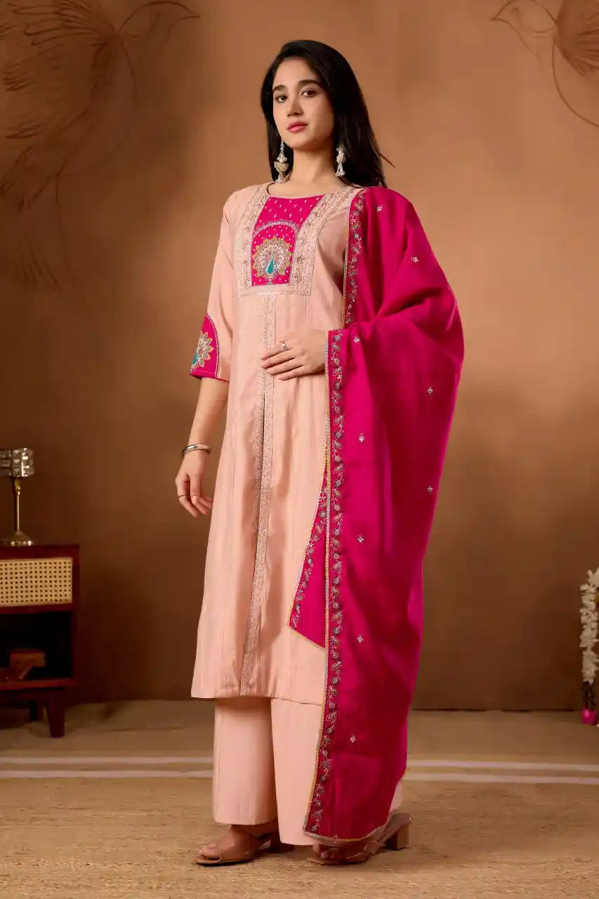 Woman wearing a traditional outfit with a pink dupatta against a brown background