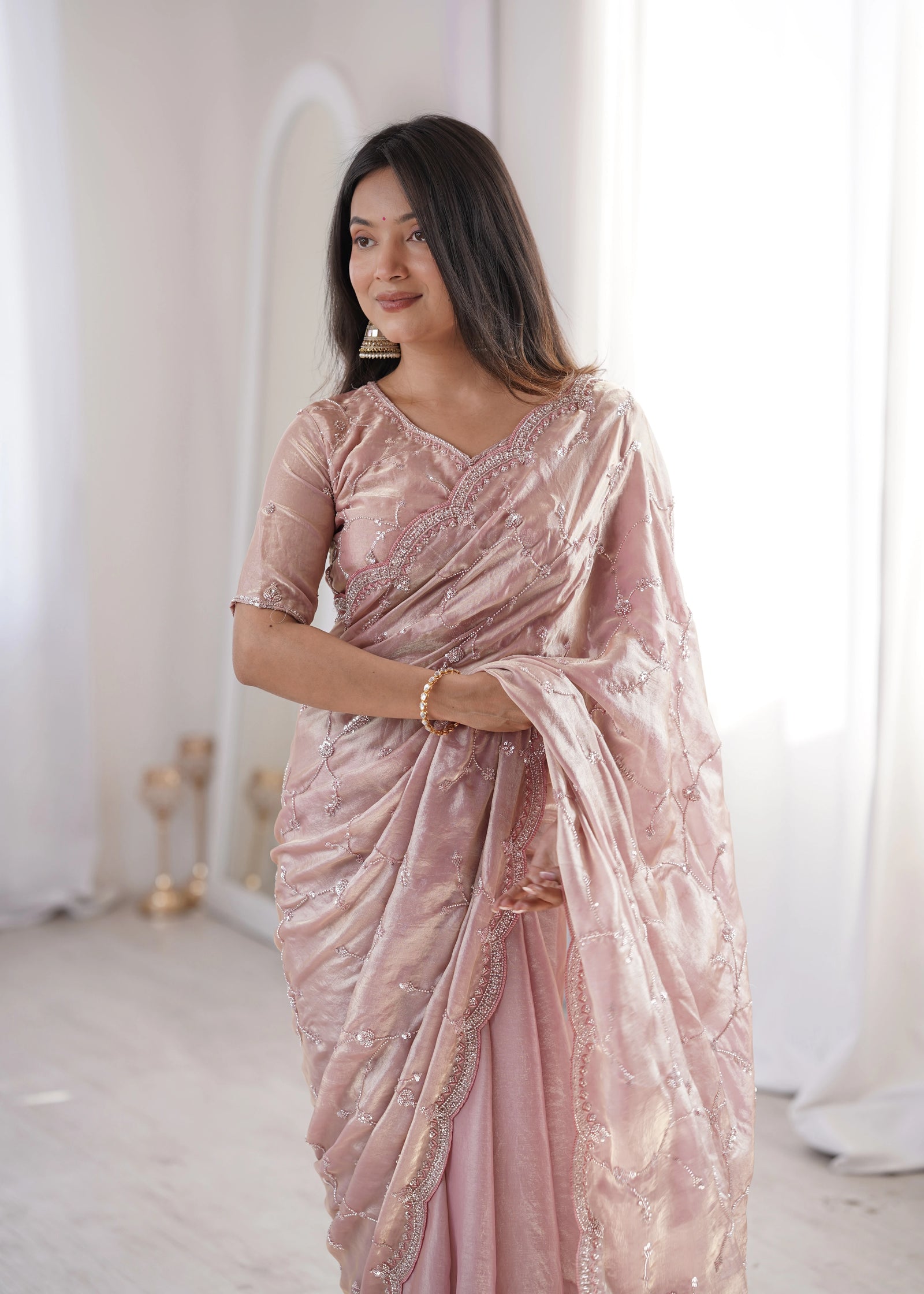 Woman wearing a pink saree with a white background