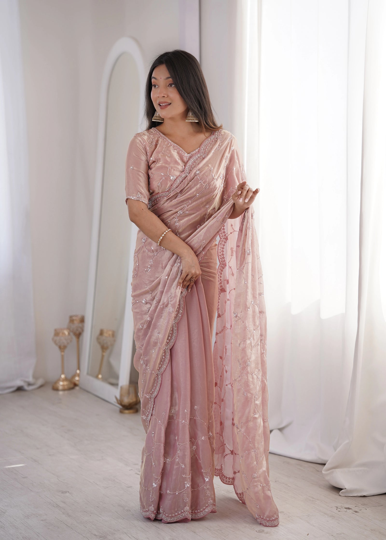 Woman wearing a pink saree with a white background