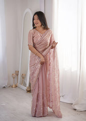 Woman wearing a pink saree with a white background