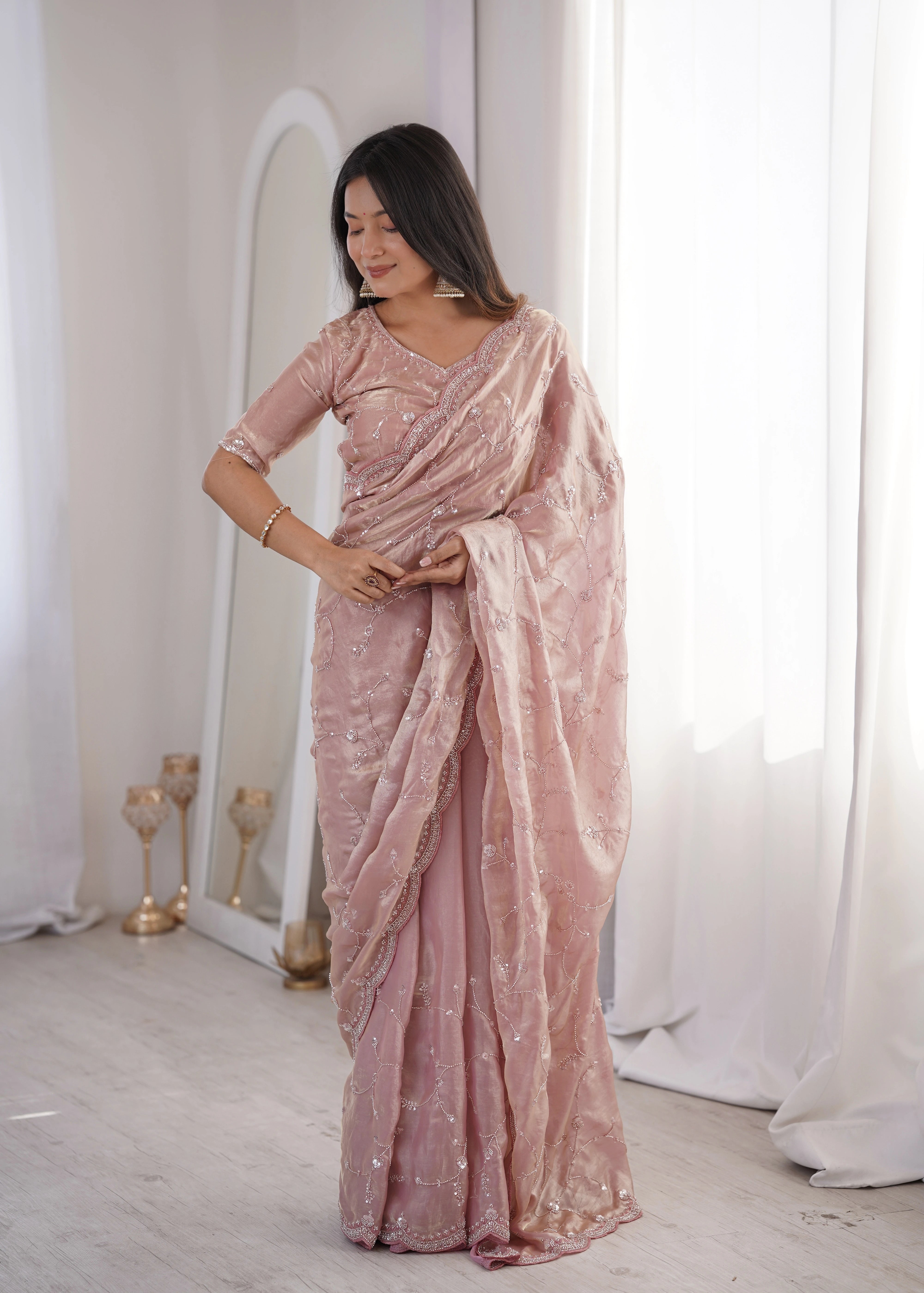 Woman wearing a pink saree with a white background