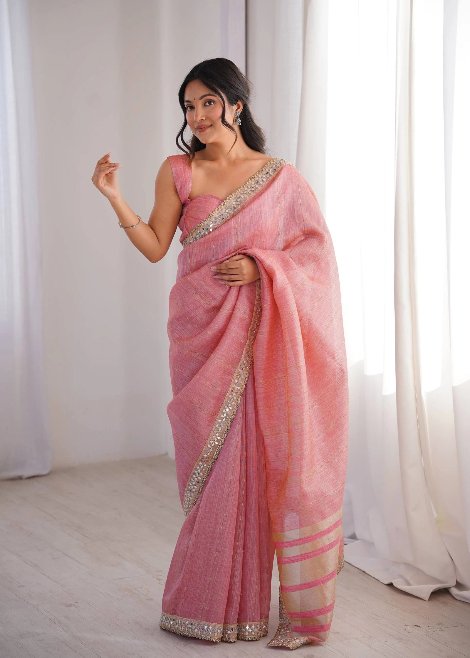 Woman wearing a pink saree with a white background