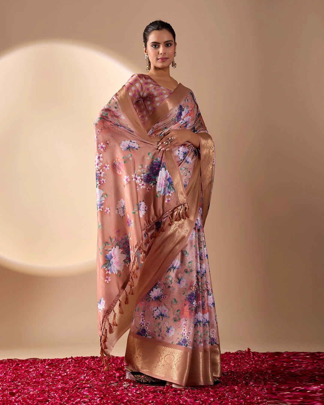 Soft pink lichi silk saree featuring a vibrant floral digital print, an elegant gold zari woven border, and tassel details by Kalyanja.