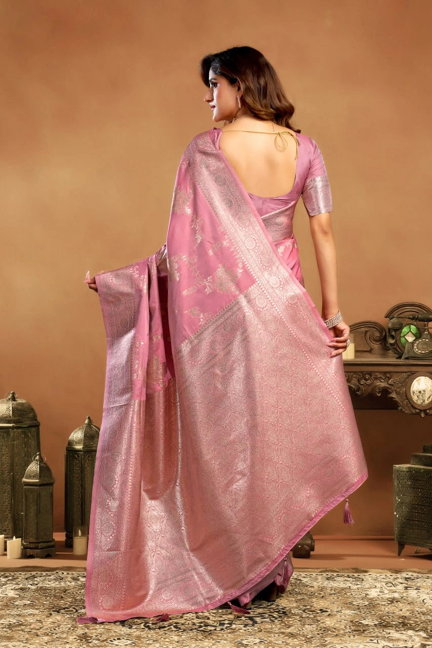 Woman wearing a pink saree with a metallic border in an indoor setting