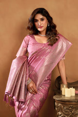 Woman in a pink saree with a gold border against a beige background