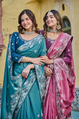 Two women in traditional sarees standing together with a architectural background
