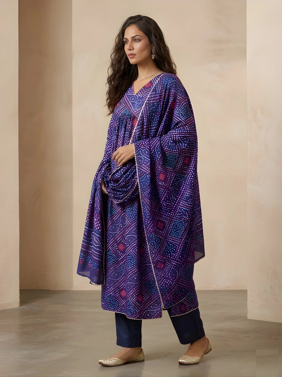 Woman wearing a purple patterned kurta with navy pants against a beige background