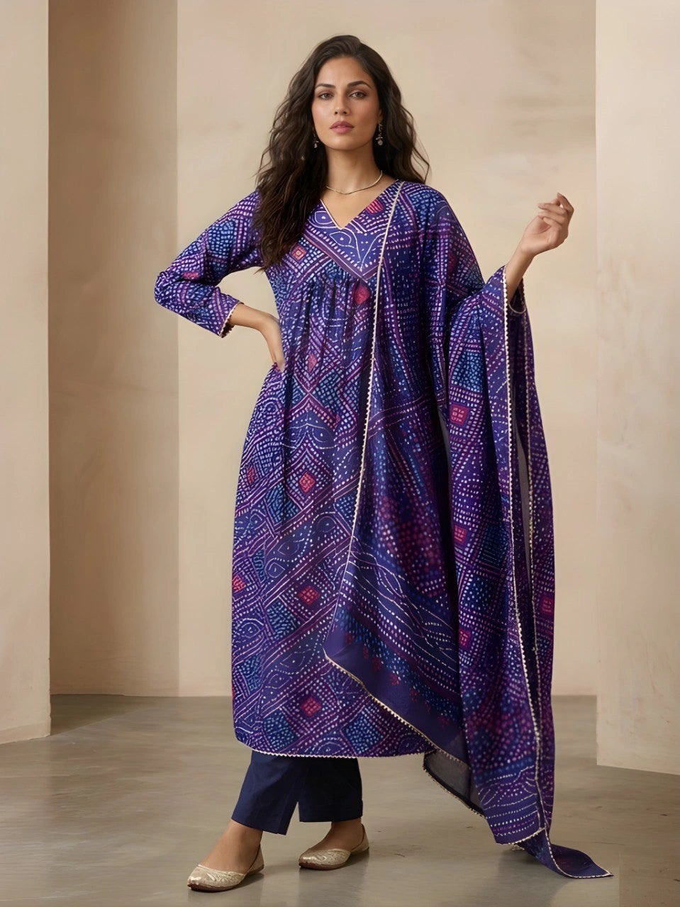 Woman wearing a blue patterned dress with a matching dupatta against a neutral background