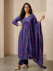 Woman wearing a blue patterned dress with a matching dupatta against a neutral background