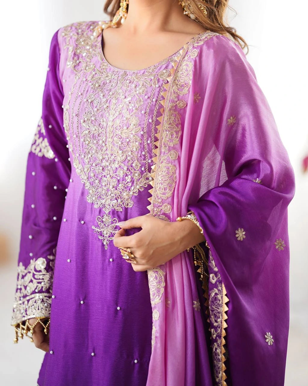 Purple embroidered traditional outfit with gold details on a white background