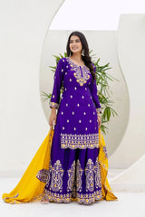 Woman wearing a purple and yellow traditional outfit with intricate designs against a white background.