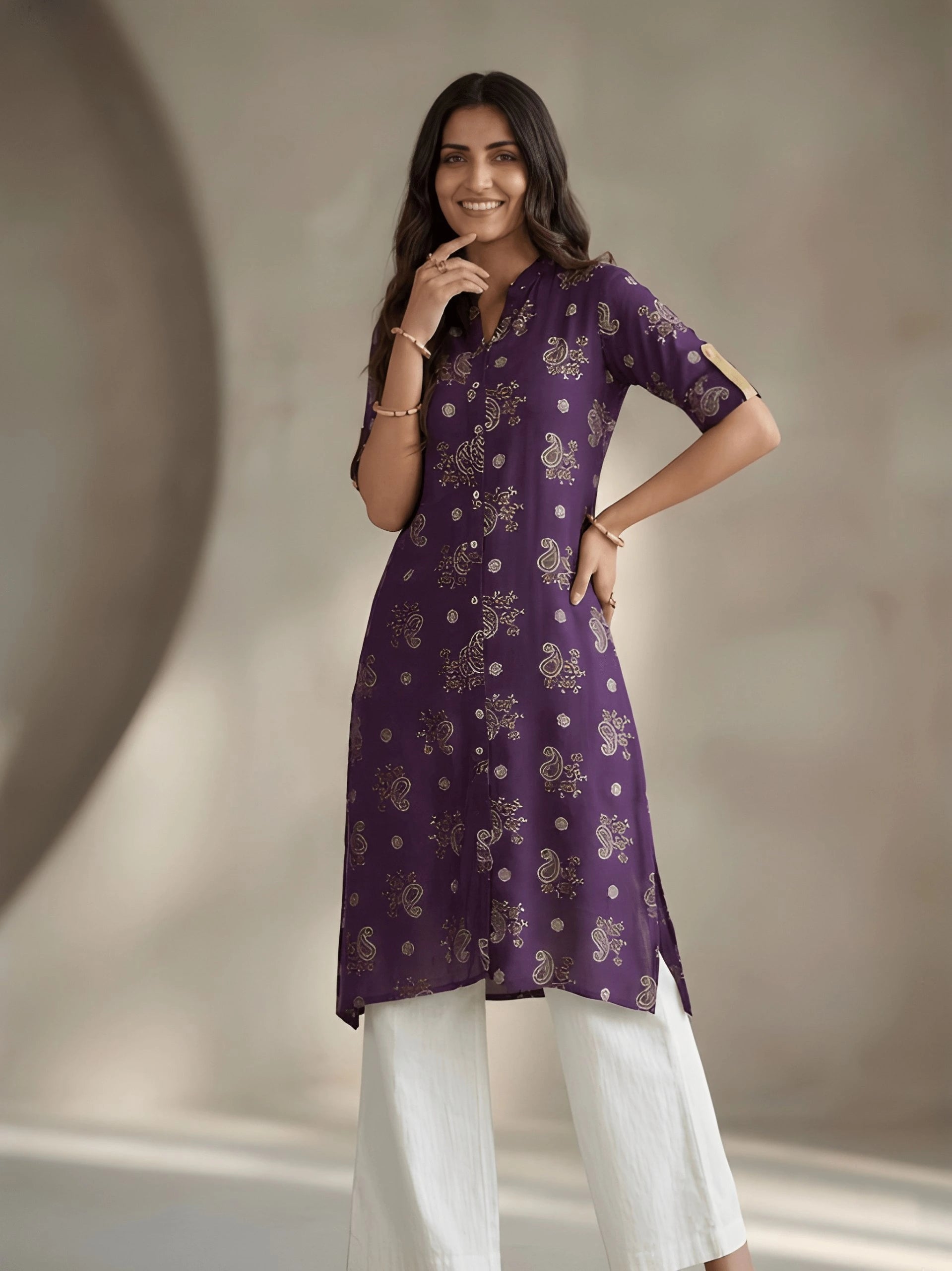Woman wearing a purple kurta with white pants against a neutral background