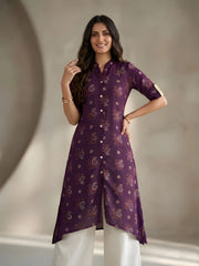 Woman wearing a purple kurta with white pants against a neutral background