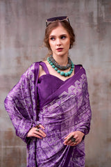 Woman wearing a purple saree with a textured background