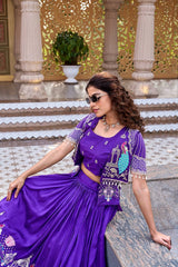 A side-profile shot of the woman seated, looking down thoughtfully. The image captures the delicate pearl fringe detailing on the hem of the jacket and the high-waisted pleats of the lehenga skirt.