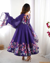 Woman wearing a purple floral dress with a sheer overlay against a white curtain background