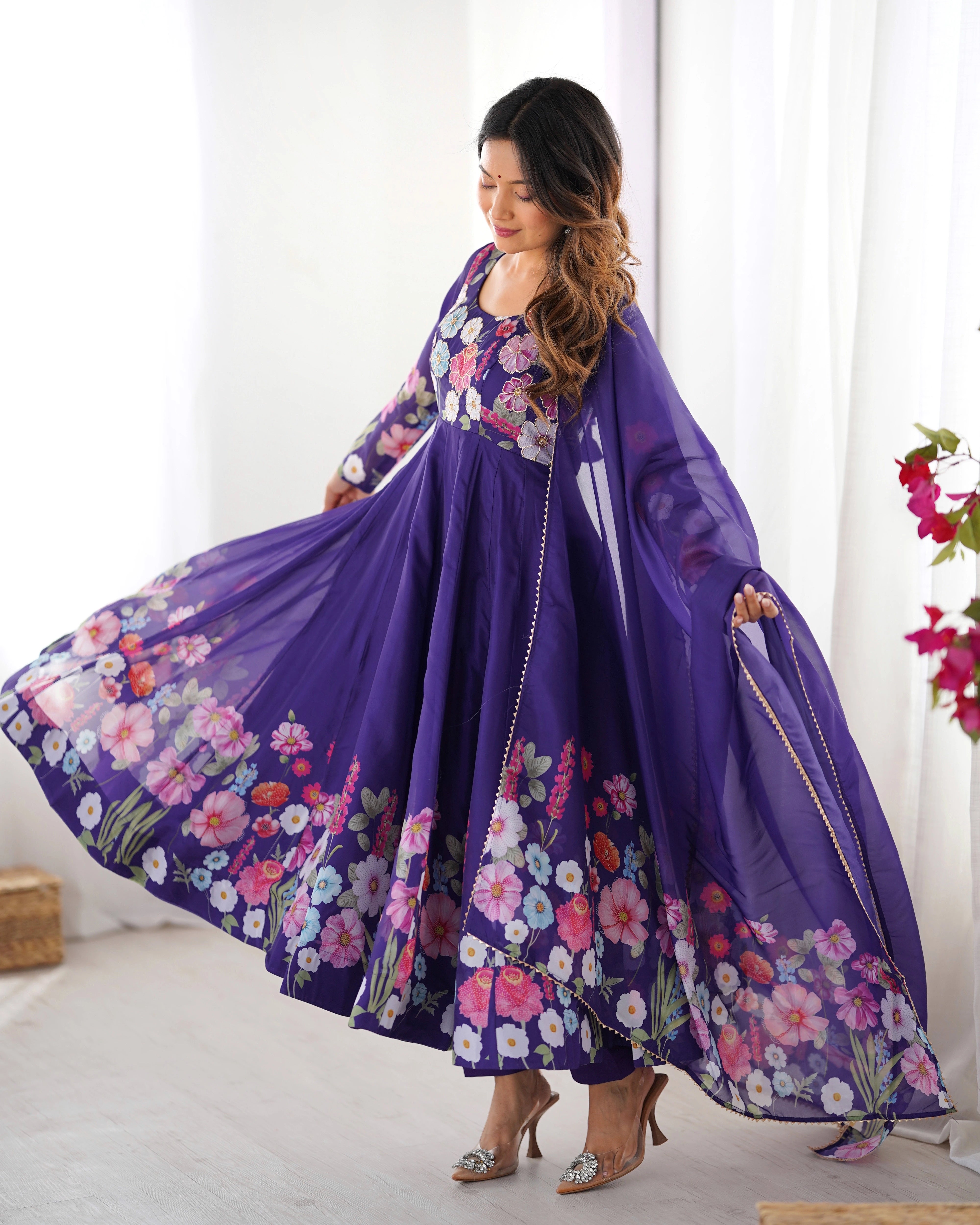 Woman wearing a purple floral dress with a white background