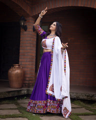 Woman in traditional Indian attire standing outdoors with a brick wall background