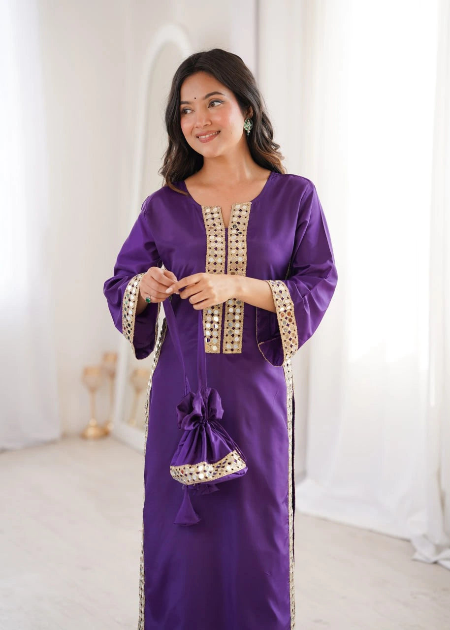 Woman wearing a purple dress with gold embroidery in a white room.