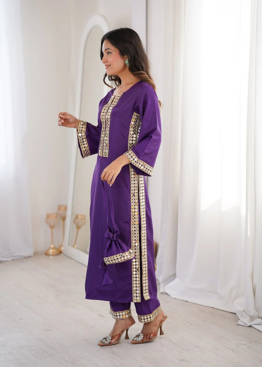 Woman wearing a purple traditional outfit with gold embroidery in a white room.