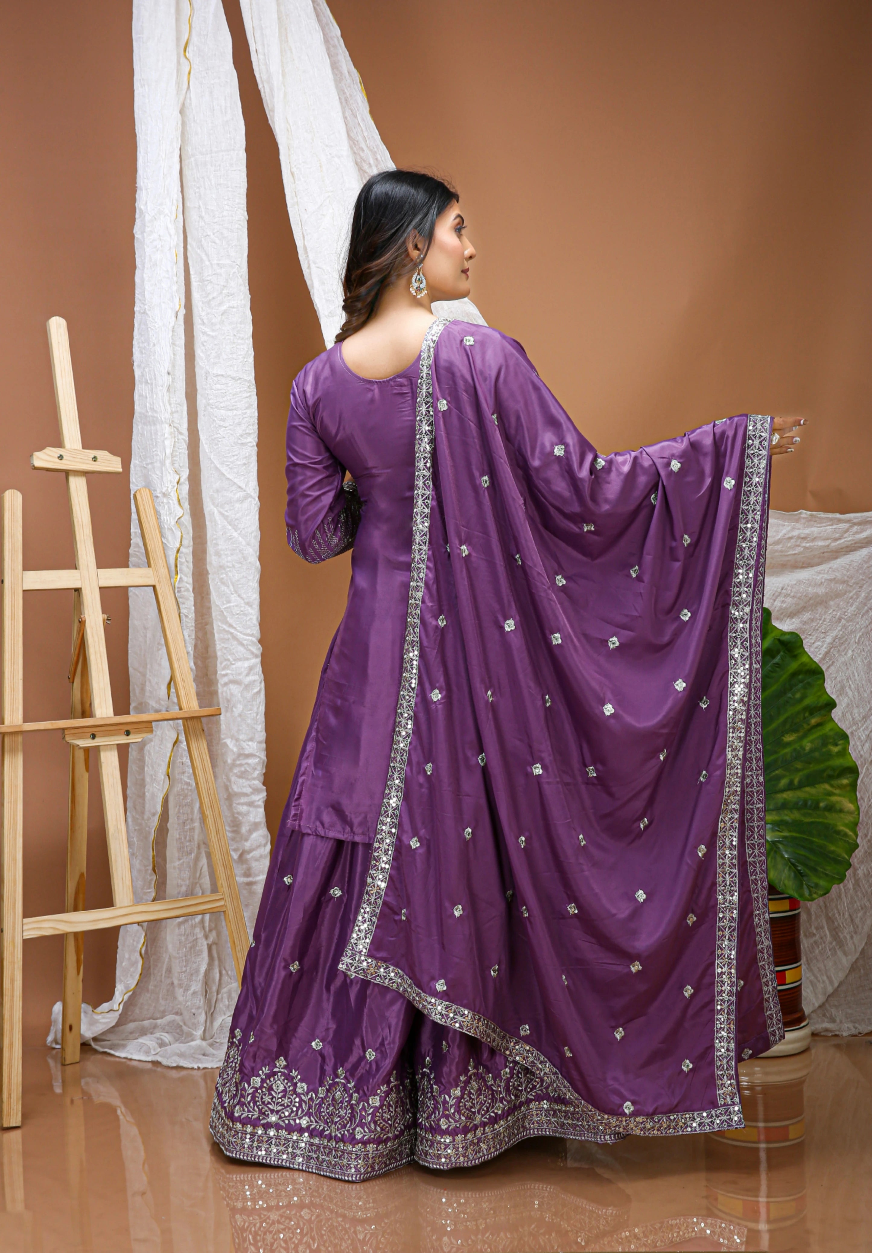 Woman in a purple traditional outfit with a brown background