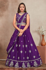 Woman wearing a purple embroidered saree with a neutral background
