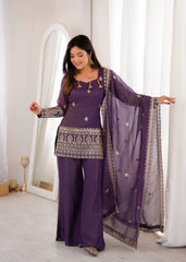 Woman in a purple traditional outfit with a matching dupatta in a well-lit room.