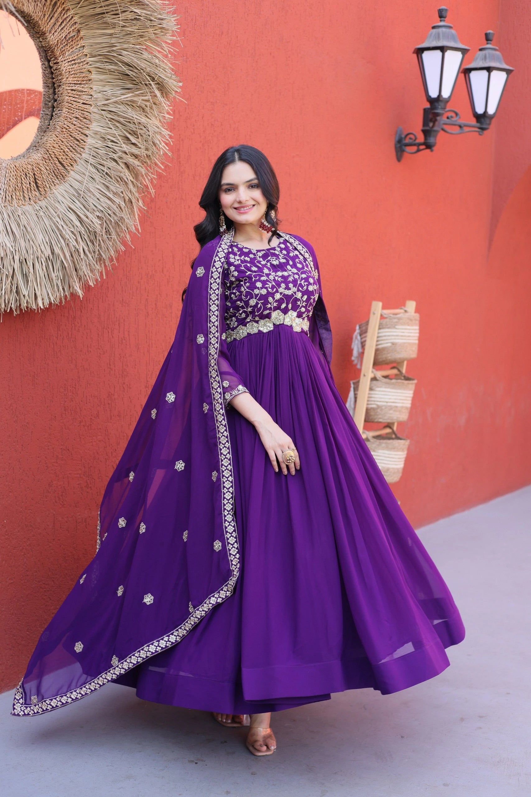 Woman in a purple traditional outfit with a red wall background