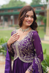 Woman wearing a purple embroidered outfit with a scenic background