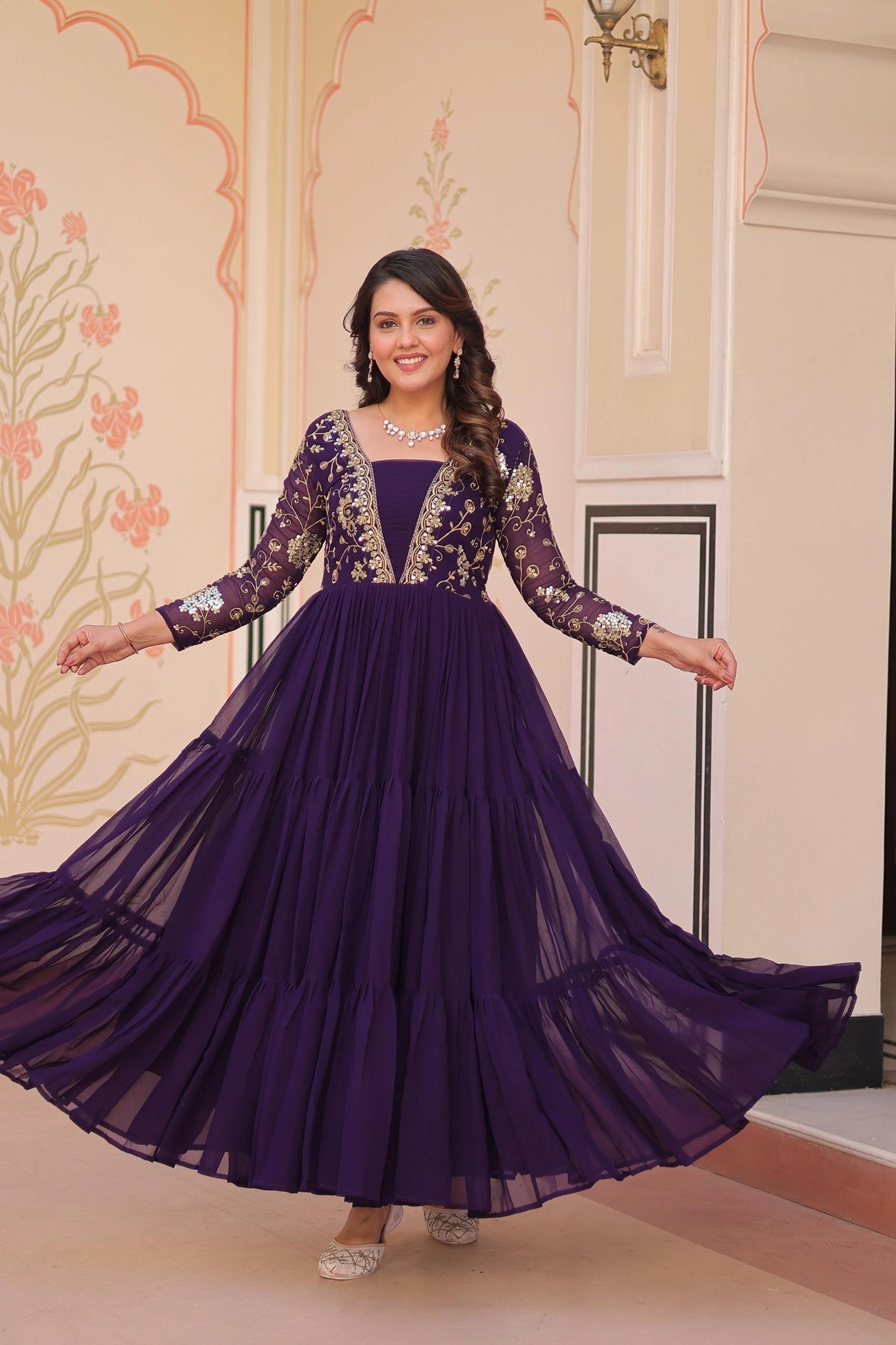 Woman in a purple gown with floral patterns in an indoor setting