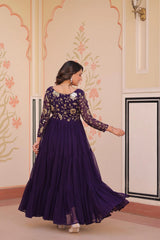Woman in a purple dress with floral patterns in an indoor setting