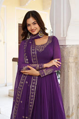 Woman wearing a purple embroidered dress standing indoors.