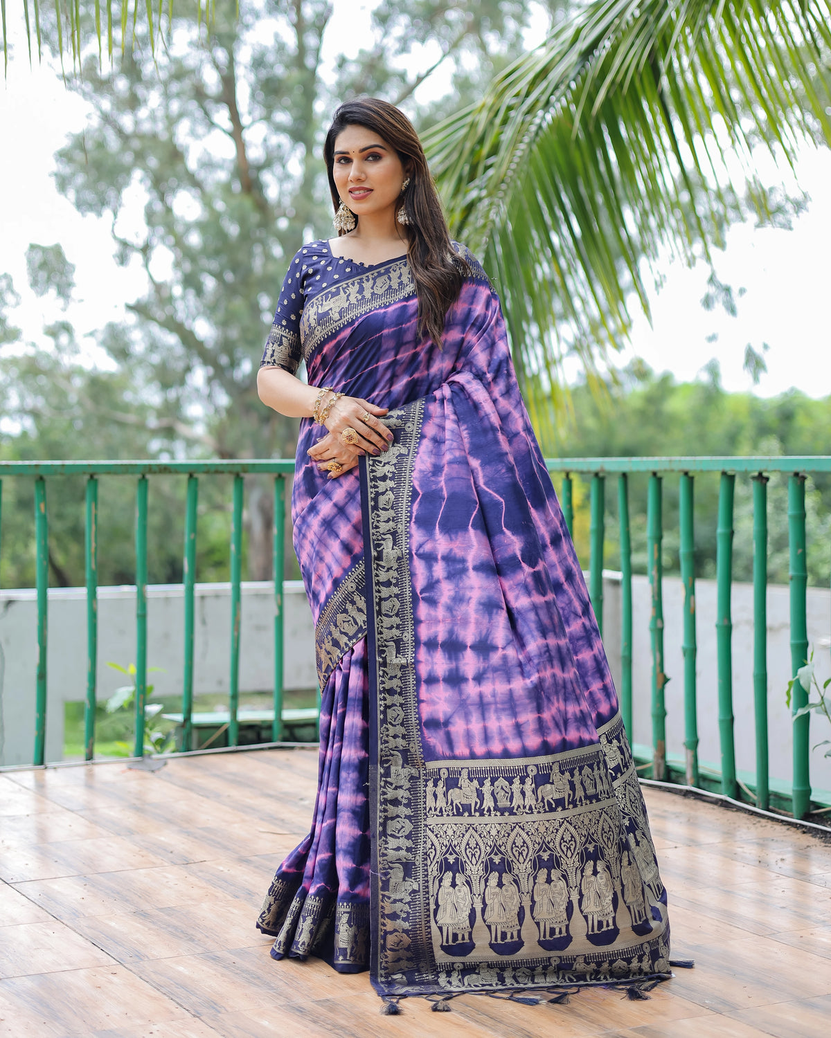 Woman wearing a purple and blue saree with a scenic background