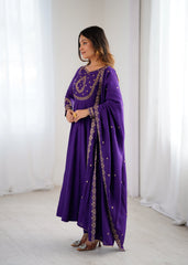 Woman wearing a purple dress with gold embroidery in a minimalistic setting