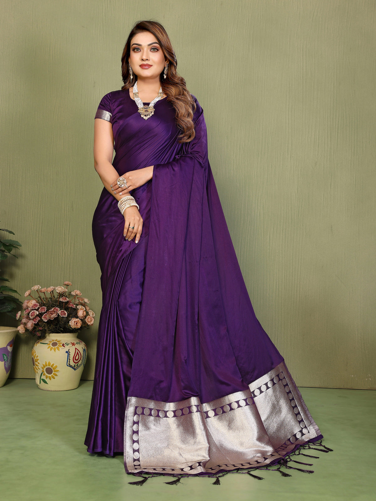 Woman wearing a purple saree with a green background