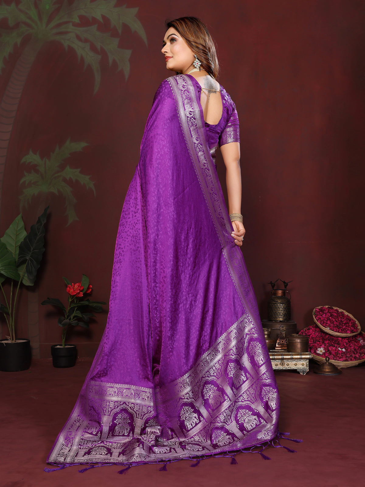 Woman wearing a purple saree with a dark background
