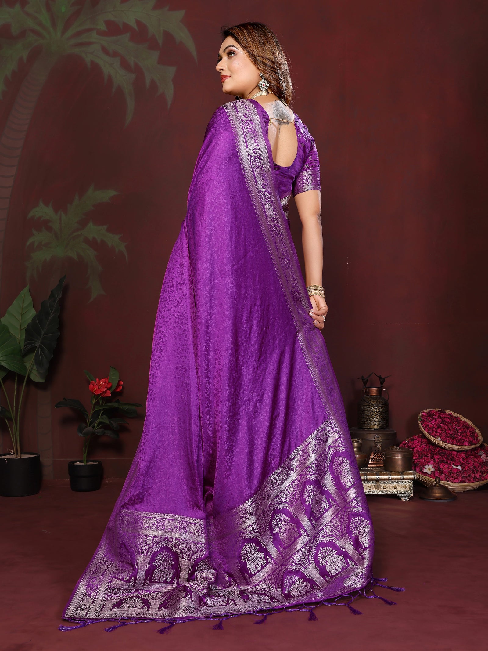 Woman wearing a purple saree with a dark background