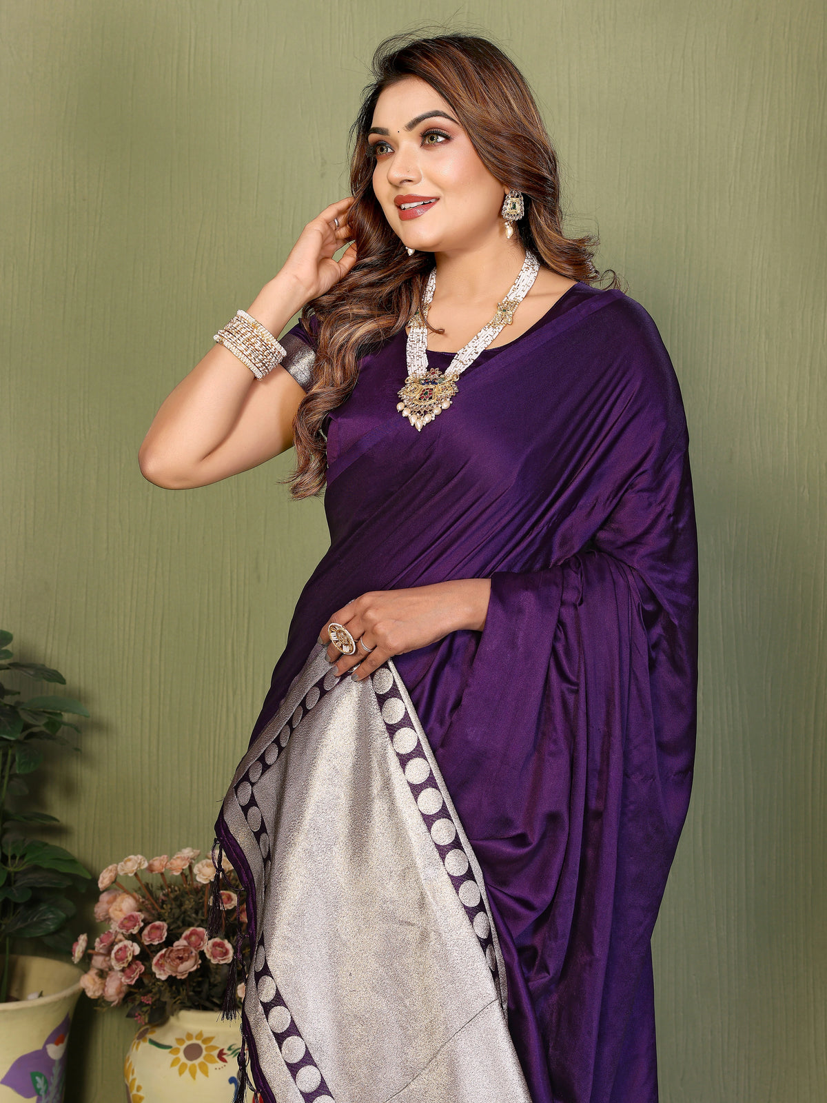 Woman wearing a purple saree with a green background