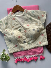 Embroidered blouse with floral patterns on a pink fabric background