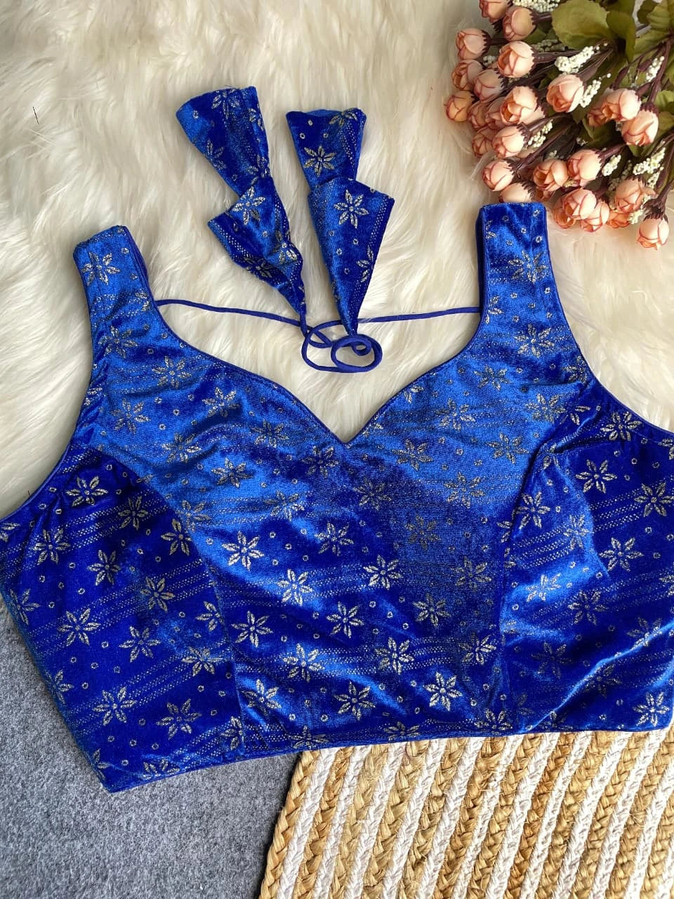 Blue floral blouse with matching sleeves on a textured surface