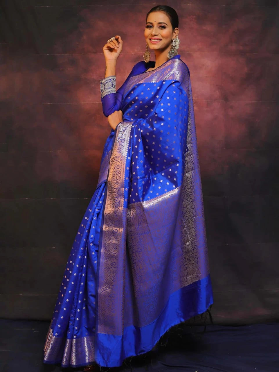 Woman wearing a blue saree with a dark background