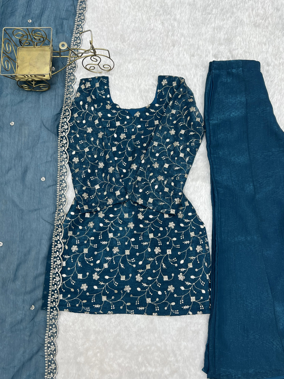 Blue floral dress with matching pants on a textured white background