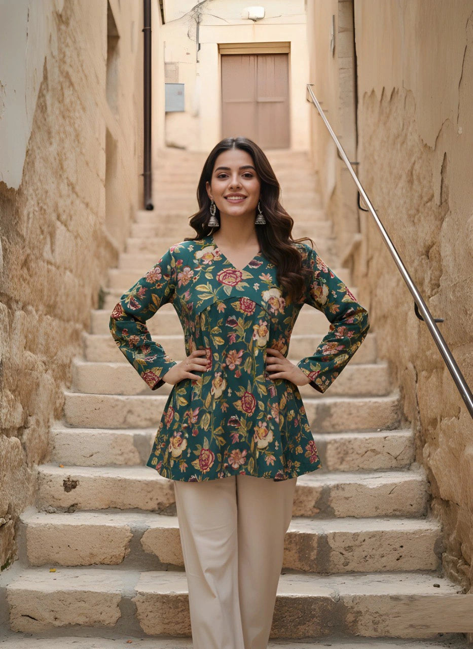 Woman in a floral top and beige pants standing on stone steps in an alleyway.