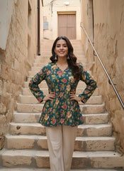 Woman in a floral top and beige pants standing on stone steps in an alleyway.