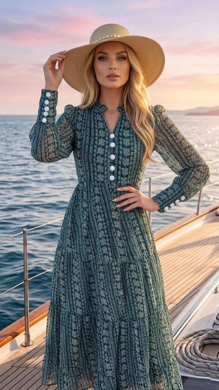 Woman in a long, patterned dress and wide-brimmed hat on a boat with a sunset background