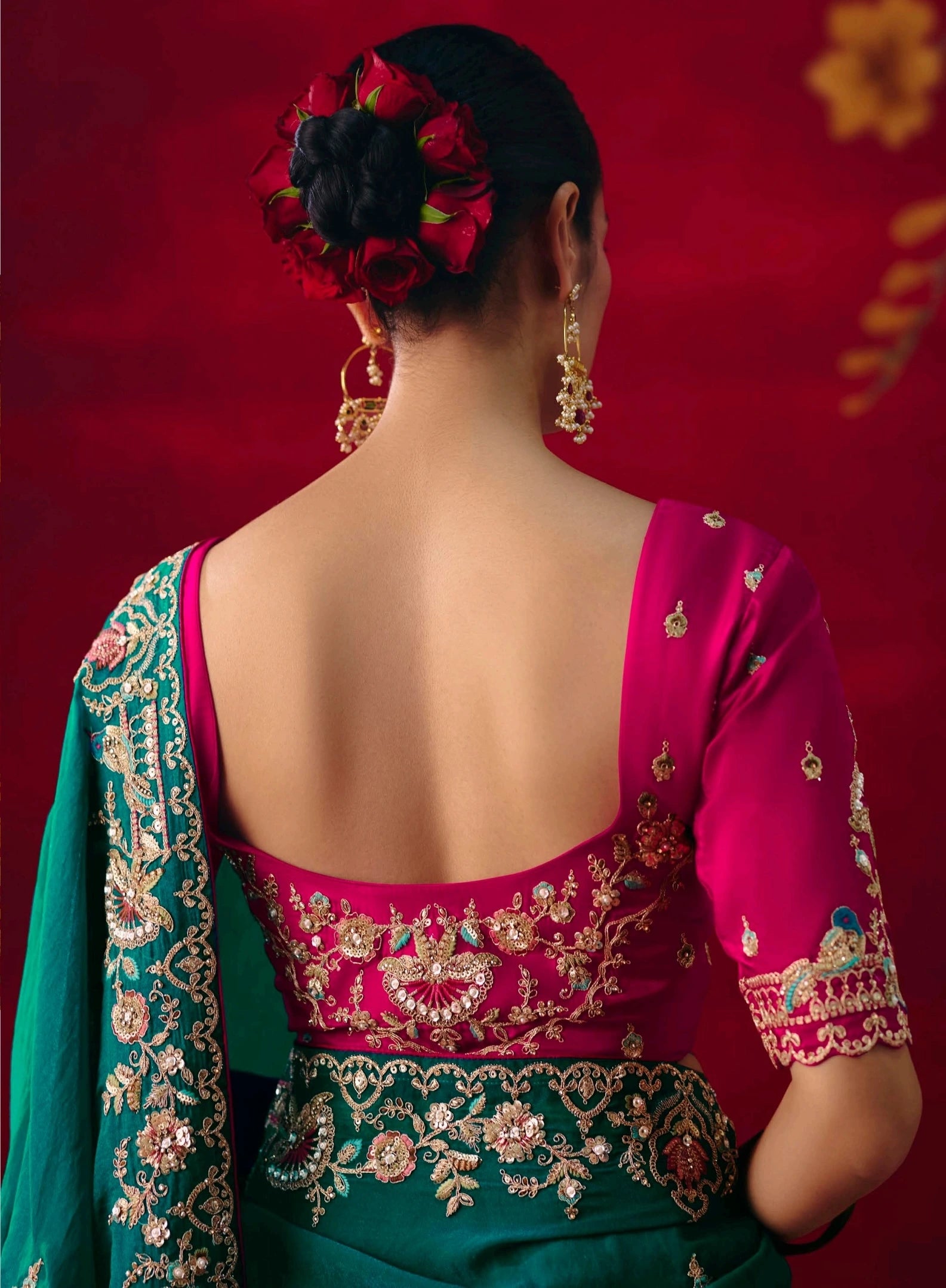 Woman wearing a traditional embroidered blouse with a red background