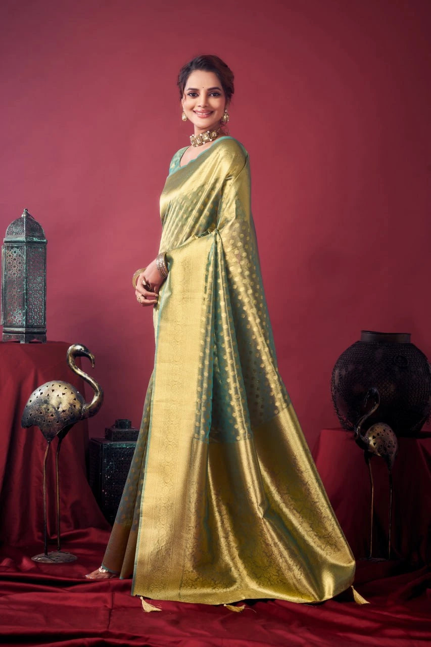 Woman in a gold saree standing against a red background